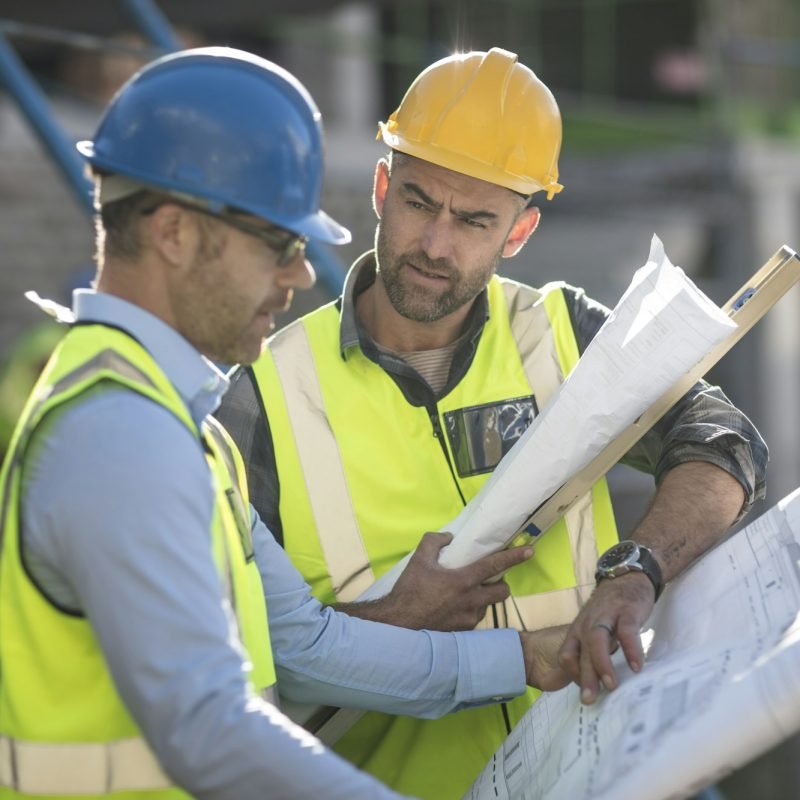 Project manager and construction worker looking at plans